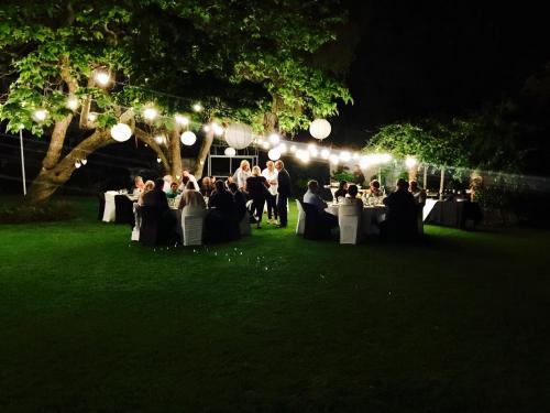 un gruppo di persone sedute ai tavoli in un parco di notte di Waterkloof Guest House a Pretoria