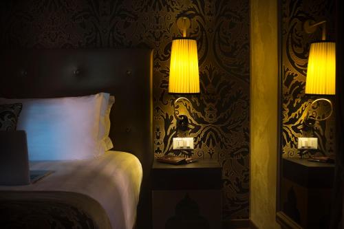 a bedroom with a bed and two lamps on a wall at Arcadia Boutique Hotel in Venice