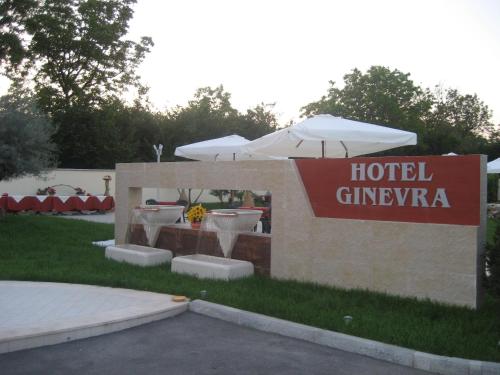 a sign for a hotel giventera with umbrellas at Hotel Ginevra in Poggiomarino
