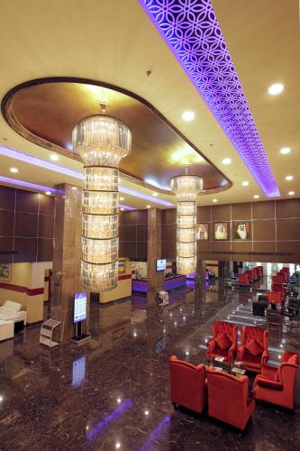 a lobby with chairs and chandeliers in a building at Park Regis Lotus Hotel in Manama