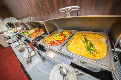 a buffet line of food on a table in a restaurant at Premier Kraków Hotel in Kraków