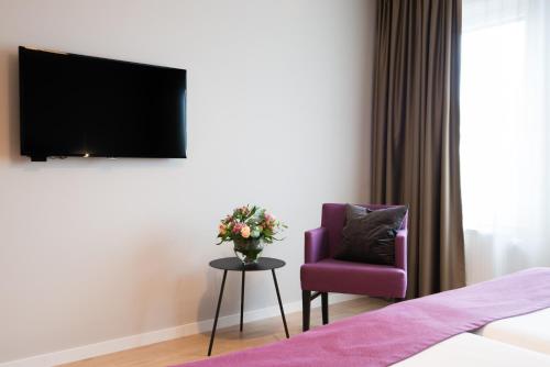 a living room filled with furniture and a tv at Best Western Plus Park Airport Hotel in Arlanda