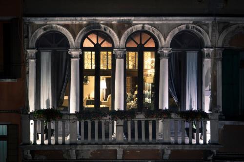 une fenêtre d'un immeuble avec des fleurs sur un balcon dans l'établissement Arcadia Boutique Hotel, à Venise