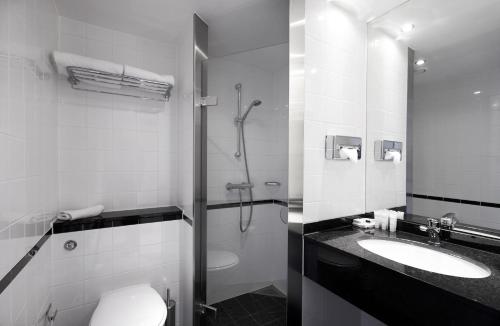 a bathroom with a shower and a toilet and a sink at Gentofte Hotel in Gentofte