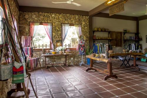 a room with stone walls and tables and windows at Khmer Hands in Kep