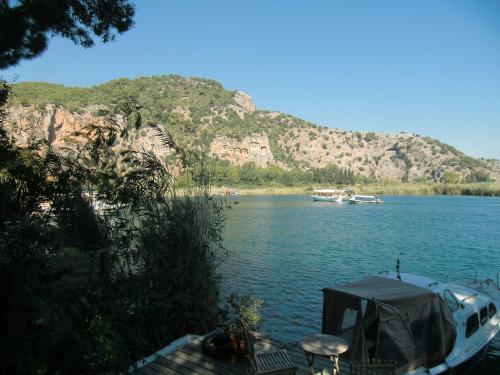 a boat on a lake with a mountain in the background at Hotel Happy Caretta in Dalyan
