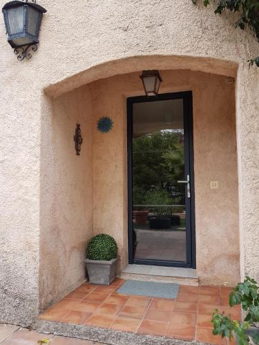 une porte menant à une maison avec une usine devant elle dans l'établissement Maison Provencale, à Cavalaire-sur-Mer