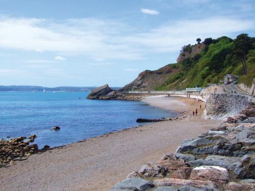a beach next to the ocean with people on it at The Babbacombe Hotel in Torquay