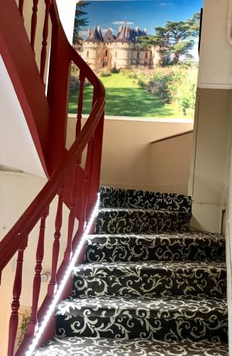 a staircase with a view of a castle at Logis Hôtel Louise de Savoie in Blois