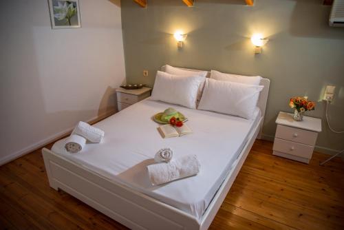 Una gran cama blanca con toallas y flores. en Iliana Villas, en Lefkada