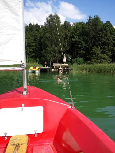 a red boat in the water with a dock at Dom Suwalszczyzna in Suwałki