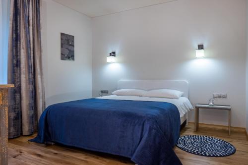 a bedroom with a bed with a blue blanket at Žvejų užeiga in Šiauliai