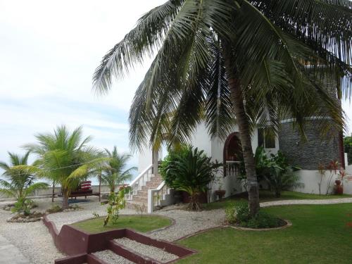 a palm tree next to a building with a bench at House Rapunzel in Oslob