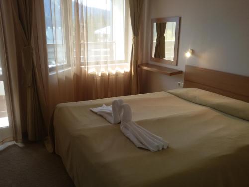 パンポロボにあるSnezhanka Apartments TMFのホテルルーム(ベッドに白いバスローブ付)