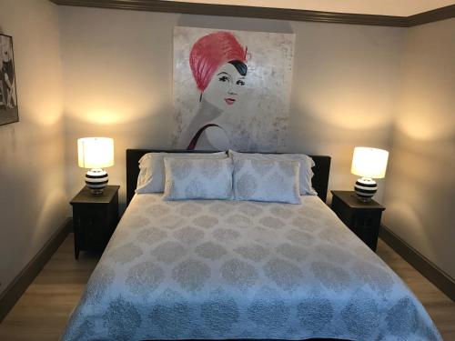 a bedroom with a bed with a painting on the wall at Elaine's Cape May Boutique Hotel in Cape May