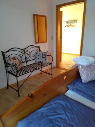 a bedroom with a bed and a chair in a room at Ferienwohnung Wisbek in Brinjahe