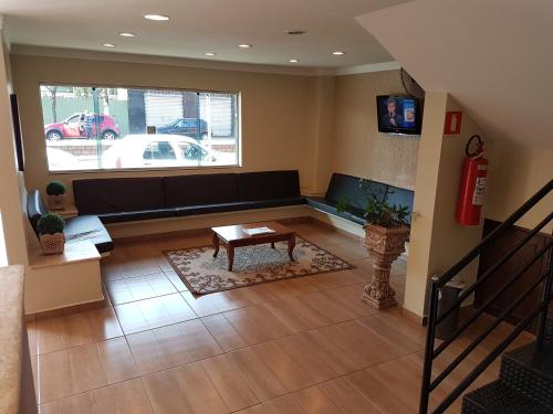 ein Wohnzimmer mit einem Sofa und einem Tisch in der Unterkunft Hotel Barretos in Barretos