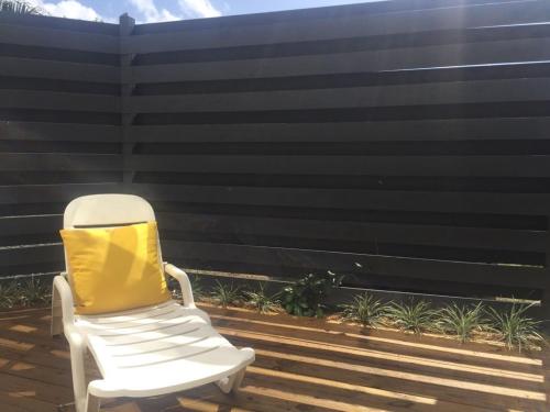 a white rocking chair sitting on a deck at C'Renity Studio in Cul de Sac