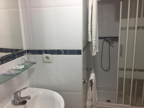La salle de bains est pourvue d'un lavabo et d'une douche. dans l'établissement Hotel San Miguel, à Altea