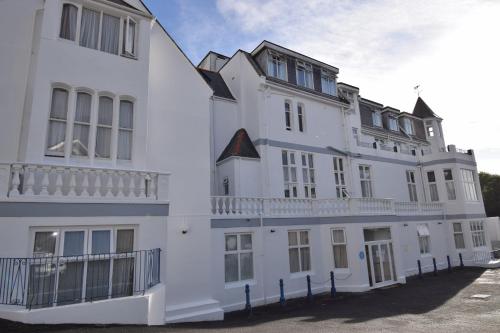 a white building with a balcony on the side of it at Riviera Hotel in Torquay