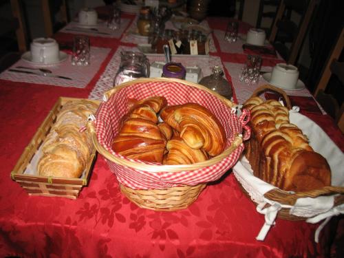 - une table avec des paniers de croissants et de viennoiseries dans l'établissement La Maison d'Héloïse, à Pruillé