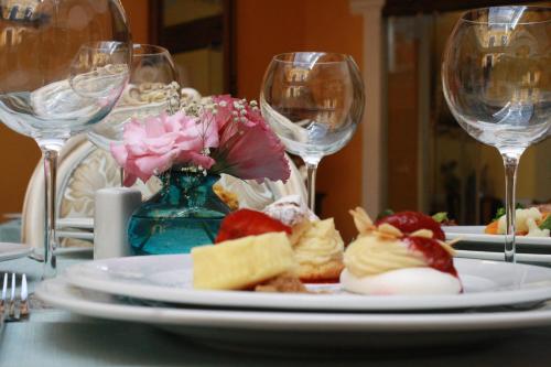 a plate of food on a table with wine glasses at Hotel Marqués del Ángel in Puebla