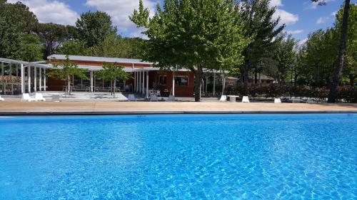 uma grande piscina azul em frente a um edifício em Camping Taimì em Marina di Massa