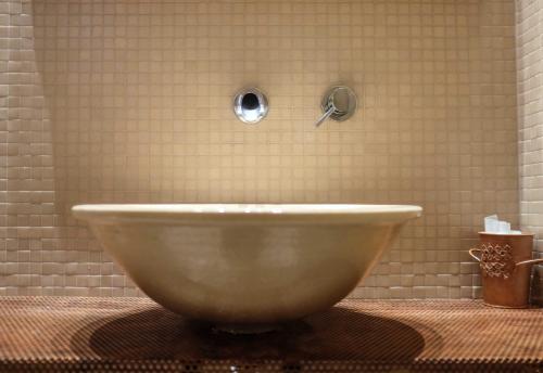 a large bowl sink in a tiled bathroom at Spazio[Bianco] in Ivrea