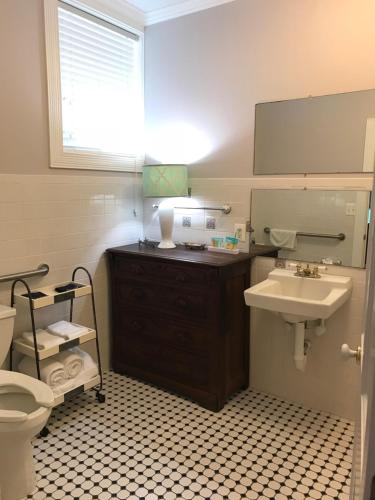 a bathroom with a sink and a toilet and a mirror at Elaine's Cape May Boutique Hotel in Cape May