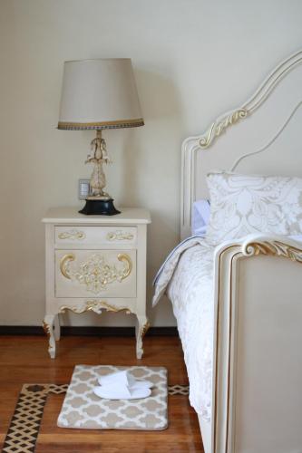 a bedroom with a bed and a table with a lamp at Hotel Marqués del Ángel in Puebla