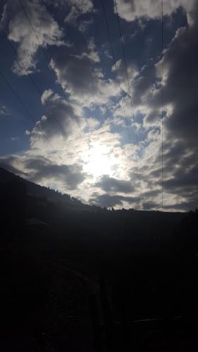 a cloudy sky with the sun in the sky at Raul Lushnu Darbaz in Mestia