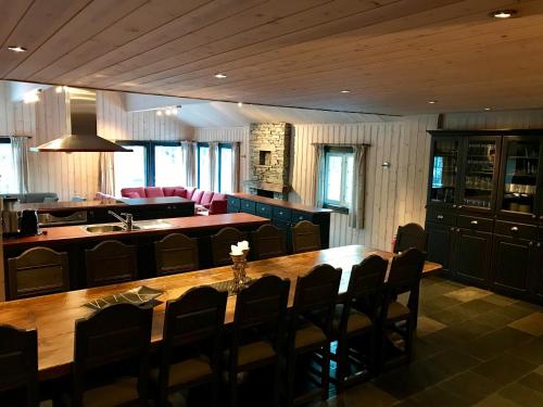 a dining room with a large wooden table and chairs at Kirkebøen Hytter in Hemsedal