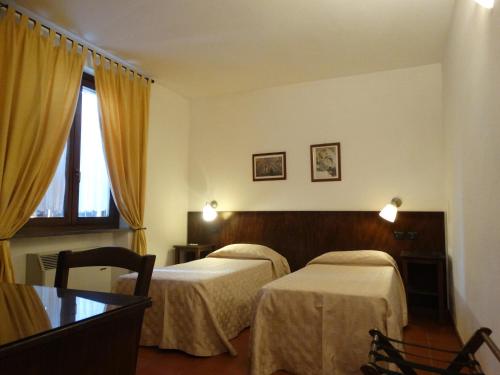 a hotel room with two beds and a window at Agriturismo Il Cerreto in Bettona