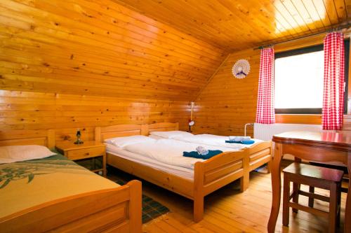 a bedroom with two beds in a wooden cabin at Turistična kmetija Perk in Solčava