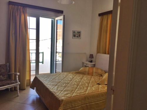 a bedroom with a bed and a door to a balcony at Papanikola House 1 in Astypalaia