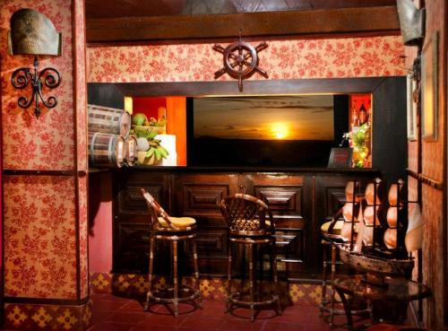 a bar with stools and a television in a room at Barbanera Club & Hotel de Charme in Caucaia