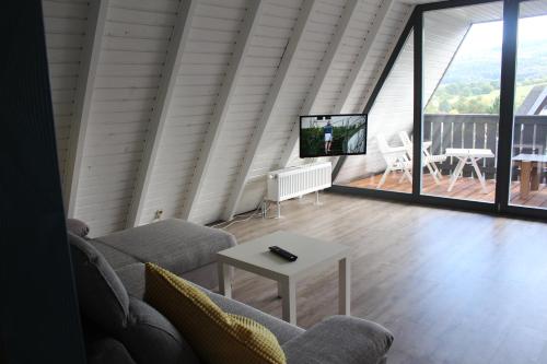 a living room with a couch and a table at Ferienhaus in der Rhön Sitzmann in Bischofsheim an der Rhön