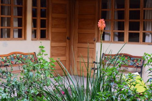 a flower in a vase on top of a house at Hostal Qorichaska in Cusco