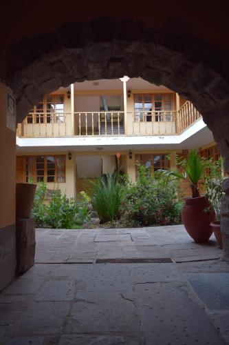 a large building with a balcony and a courtyard at Hostal Qorichaska in Cusco