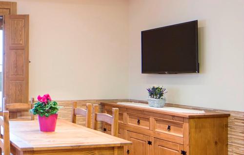 a dining room with a table and a flat screen tv at Casa Rural Francisca in Requena