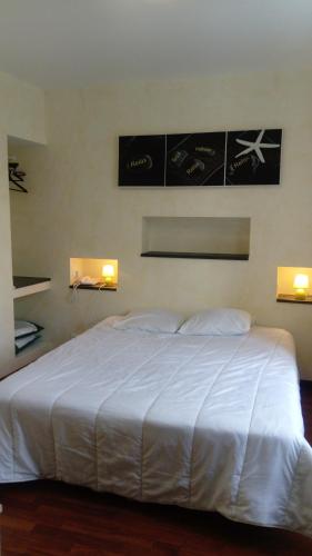 - un grand lit blanc dans une chambre avec deux lumières dans l'établissement HOTEL L'AMERIVIERE***, à Aubrives