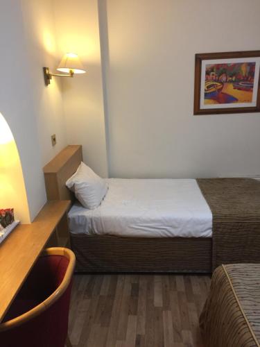 a small hotel room with a bed and a desk at Crescent Hotel in Reading