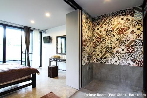 a bedroom with a wall covered in a wall mural at Lamphu House Chiang Mai in Chiang Mai