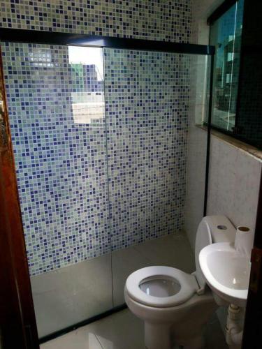 a bathroom with a toilet and a sink at Hotel Reobot in Garanhuns