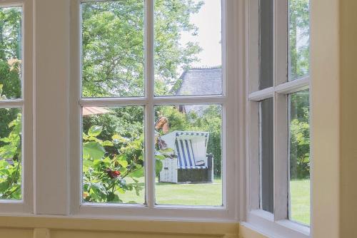 a window with a view of a chair in the yard at Haus Flora in Keitum