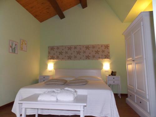 a bedroom with a white bed with two pillows on it at Ca' Virginia Country House Wellness in Montecalvo in Foglia