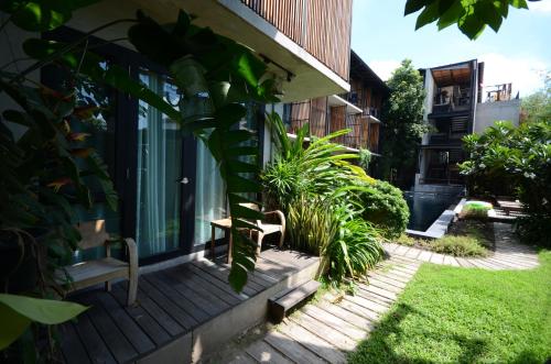 a house with a bench on a porch at Lamphu House Chiang Mai in Chiang Mai