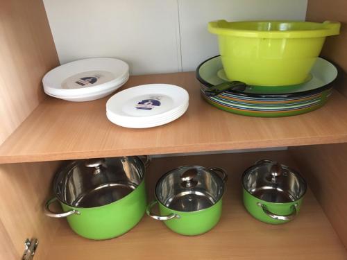 a shelf with plates and pots and pans at Apartment Smestaj B in Novi Pazar