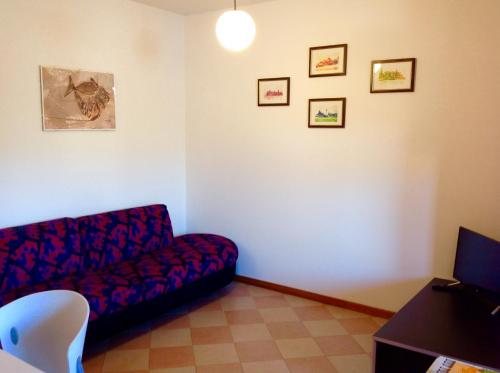a living room with a couch and pictures on the wall at Paola Apartments in SantʼAmbrogio di Valpolicella