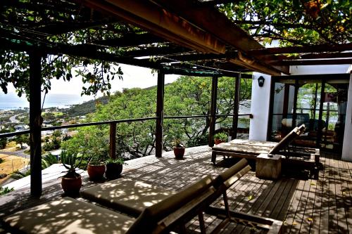 a porch with a bench and a view of the ocean at Boutique@10 in Cape Town